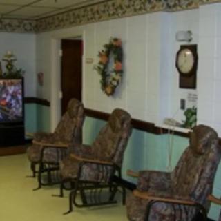 A cozy waiting room with patterned chairs, a wall clock, and a vending machine.