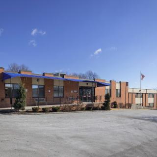 A brick commercial building under a clear blue sky.