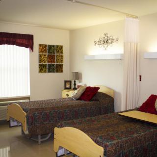 A clean and organized hospital room with two twin beds.