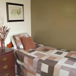 A minimalist bedroom with a neatly made bed and simple decor.