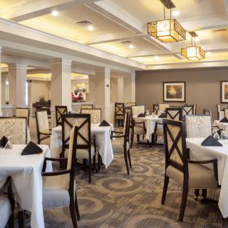 An elegant restaurant dining room with well-arranged tables and chairs.