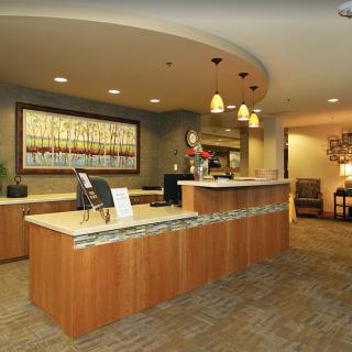 A modern reception area with a curved desk, decorative lighting, and contemporary decor.