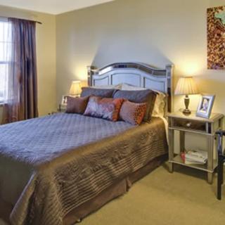 A cozy bedroom with a neatly made bed, two nightstands, and lamps for ambient lighting.