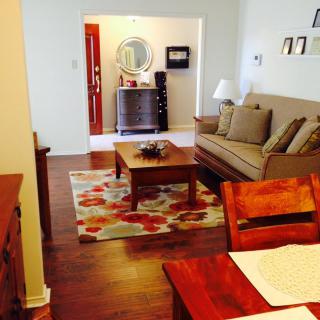 A cozy living room with a sofa, coffee table, and decorative rug on a wooden floor.