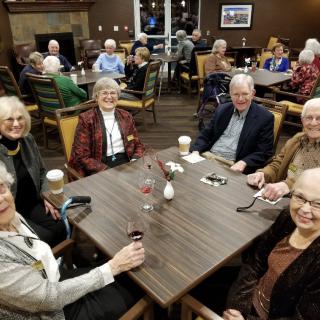 A group of seniors enjoying a social gathering with coffee indoors.