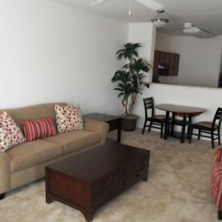 A cozy living room featuring a comfortable sofa, a coffee table, and a dining area.
