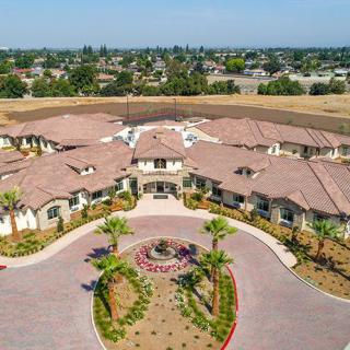 Aerial view of a large residential building with landscaped surroundings in a suburban setting.