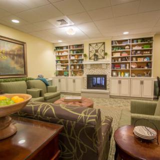 A cozy living room with comfortable seating, bookshelves, and a fireplace.