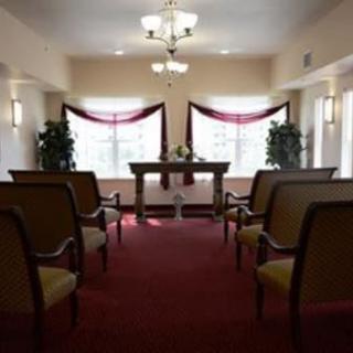 An interior view of a small chapel with rows of chairs and an altar.