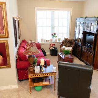 A cozy living room with a red sofa, chairs, and a television.