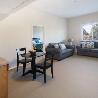 A spacious living room with modern furniture, including two sofas and a dining table set.