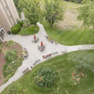 Aerial view of a garden area with outdoor seating, surrounded by lush greenery and pathways.