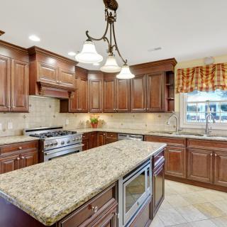 A modern kitchen with wooden cabinets and a granite countertop island.