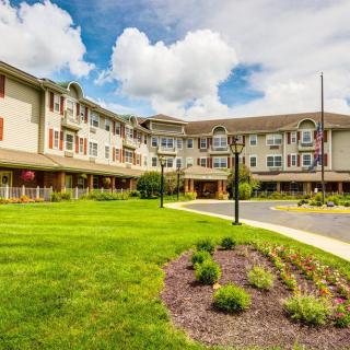 Beautiful residential building with well-maintained landscaping under a cloudy sky.