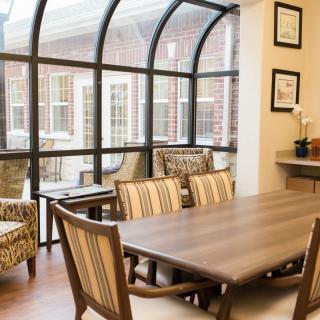 A cozy dining area with a large window allowing natural light to brighten the space.