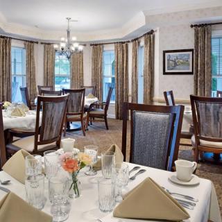 An elegant dining room with well-set tables and a chandelier.