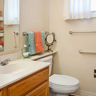 A tidy bathroom with a vanity, towels, and a mirror.