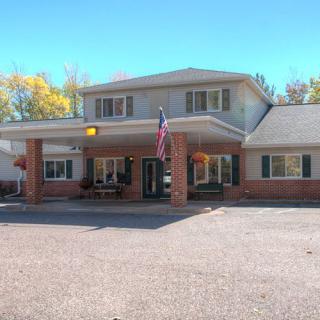 A building with an American flag at the entrance and a parking lot in front.