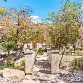 A scenic garden pathway surrounded by trees and natural landscaping.