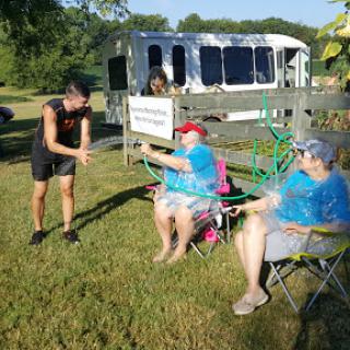 Enjoying a sunny day outdoors, socializing in camping chairs.
