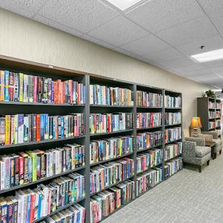 A well-organized library featuring shelves filled with a variety of books, creating an inviting reading atmosphere.