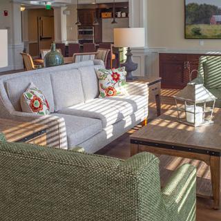A cozy living room with comfortable seating and sunlight streaming through the windows.