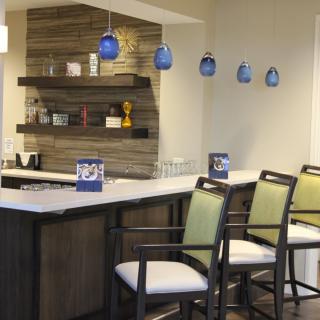 A modern kitchen bar area with sleek pendant lights and comfortable seating.