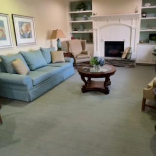 A cozy living room with a blue sofa, coffee table, and fireplace surrounded by shelves.