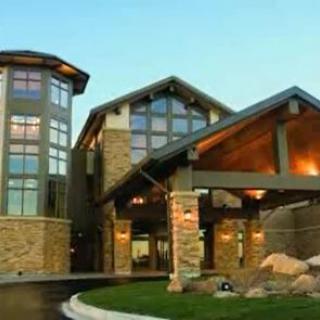 A modern residential building with stone exterior and large glass windows.
