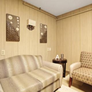 A cozy living room with a striped sofa, patterned armchair, and decorative wall art.