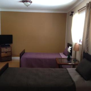 A cozy bedroom with twin beds and a TV.