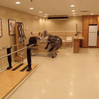 A physical therapy room equipped with parallel bars and exercise equipment for rehabilitation purposes.