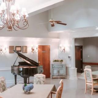 Elegant dining area with a grand piano and chandelier.