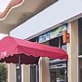 A storefront with a red awning outside a building.