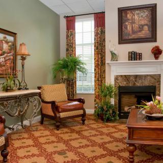 A cozy living room featuring elegant furniture, a fireplace, and decorative elements.