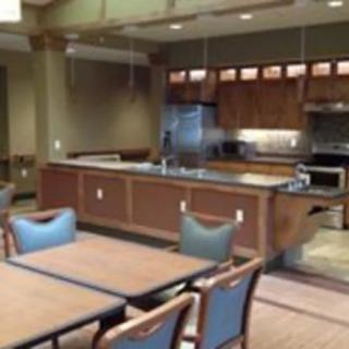 A modern kitchen and dining area with wooden cabinetry and comfortable seating.