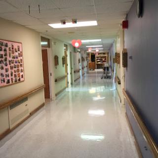 A clean and well-lit hallway inside a hospital, featuring walls adorned with photographs.