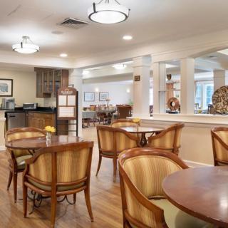 A well-lit dining area with wooden chairs and tables in a restaurant setting.