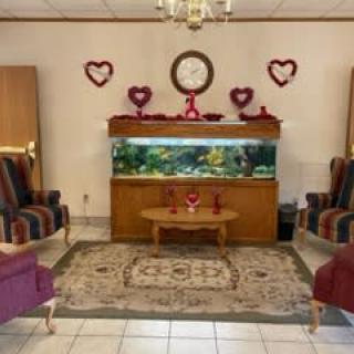 A cozy living room with an aquarium, heart-shaped decorations, and comfortable seating.