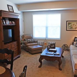 A cozy living room setup featuring a comfortable sofa, a coffee table, and ample natural light from the window.