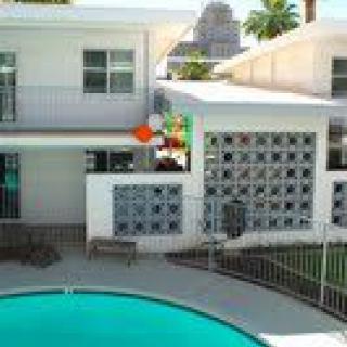 A mid-century modern house with a swimming pool in the foreground.