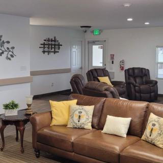 A cozy living room with brown leather couches and decorative pillows.