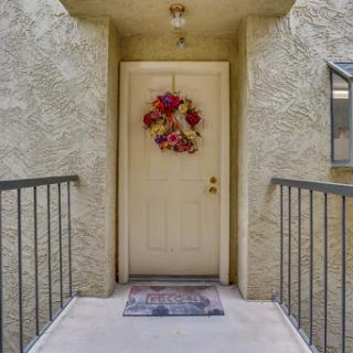 A welcoming entrance featuring a decorative wreath and a cozy welcome mat.
