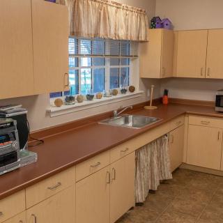 A cozy kitchen with light-colored cabinets and a window above the sink.