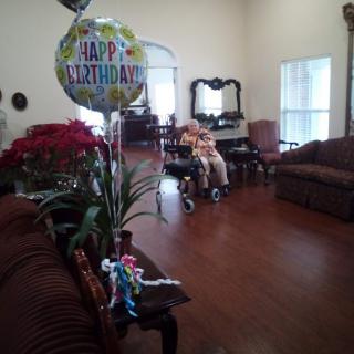 A living room decorated for a birthday celebration with balloons and festive decorations.