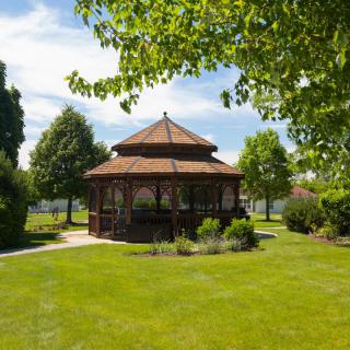A picturesque gazebo surrounded by lush greenery in a serene park setting.