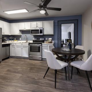 A modern kitchen and dining area with stainless steel appliances and chic furnishings.