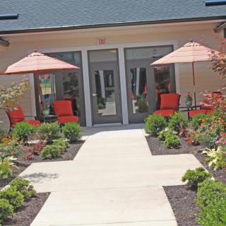 A well-maintained patio area with comfortable seating, umbrellas, and vibrant landscaping.