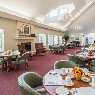 Brightly lit dining room with neatly arranged tables and chairs.