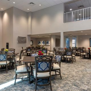 A modern dining area with neatly arranged tables and chairs, featuring elegant decor.